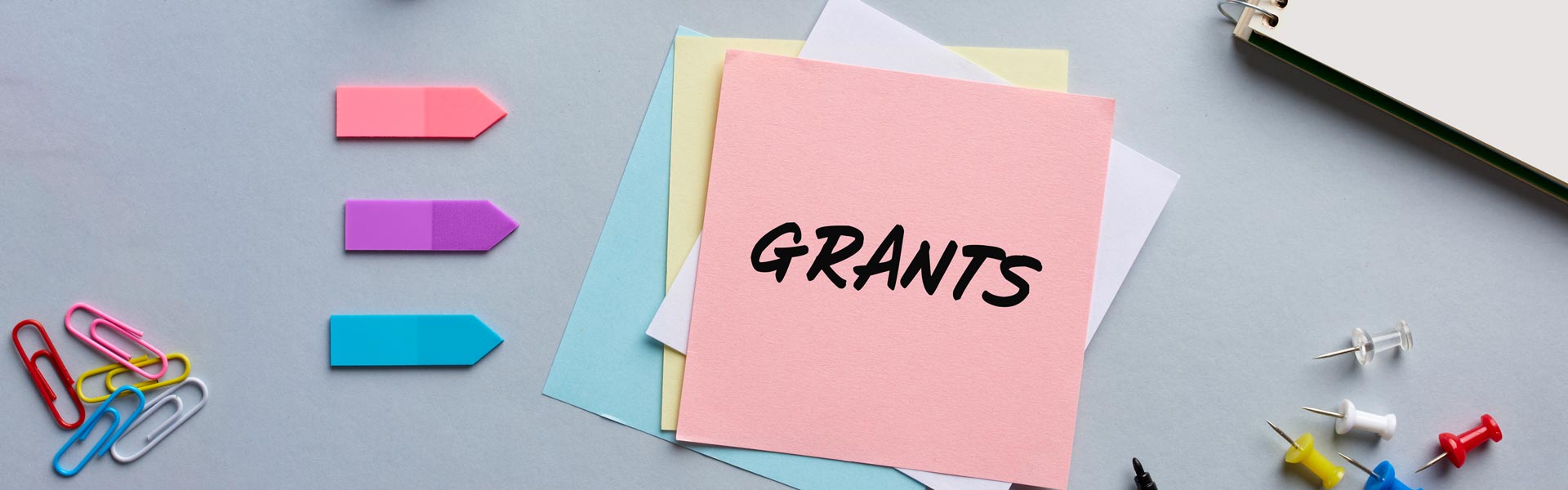 Office supplies and post-it with "Grants" written on it